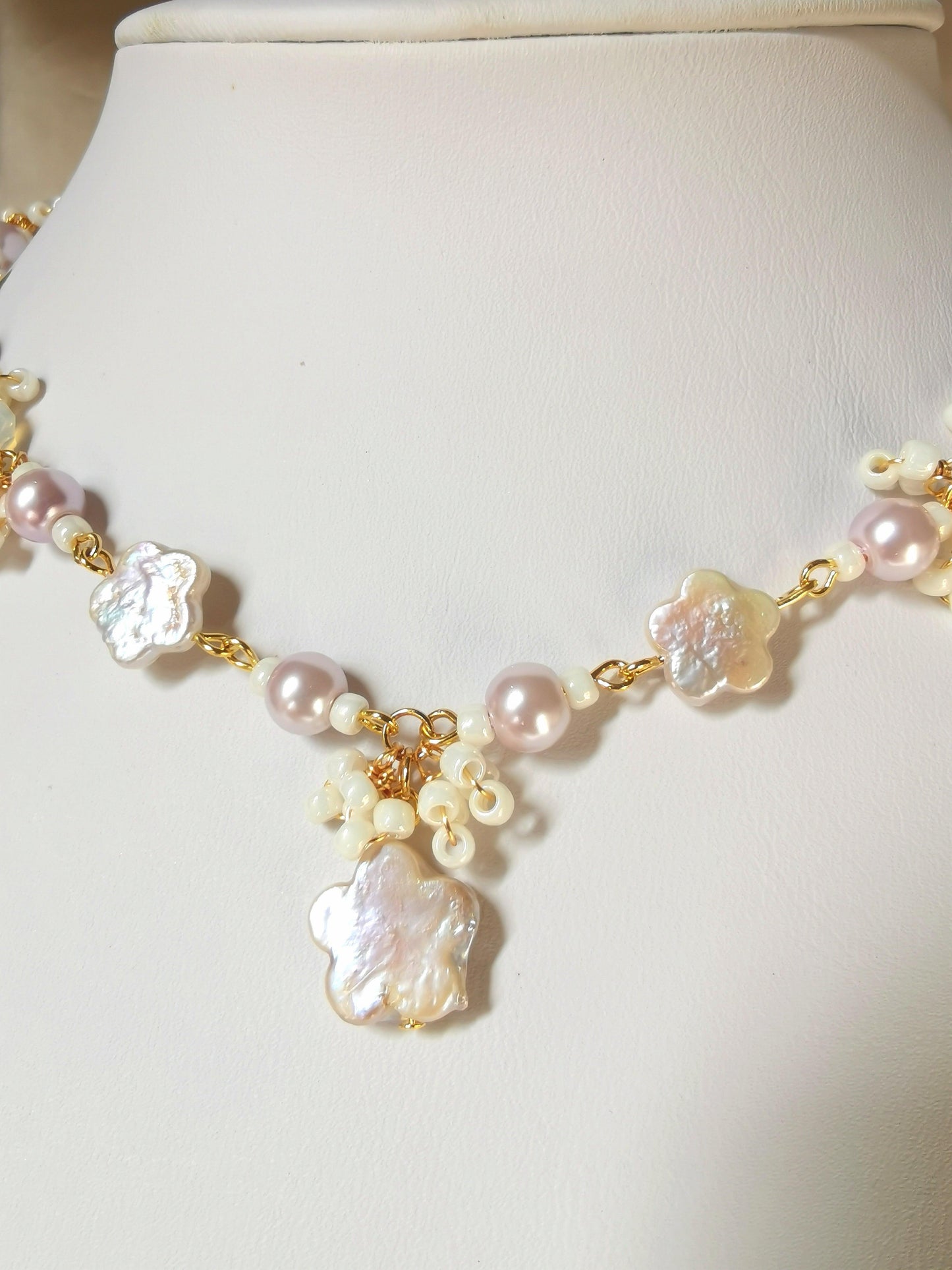 This Primrose Pearl Necklace is a sweet handmade pearl necklace that uses flower-shaped freshwater pearls and lovely lilac crystal pearls. Dainty seed bead details adorn the whole necklace, giving it an elegant and delicate look.