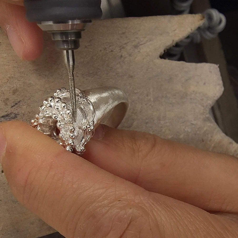 Working on a silver ring at the bench.