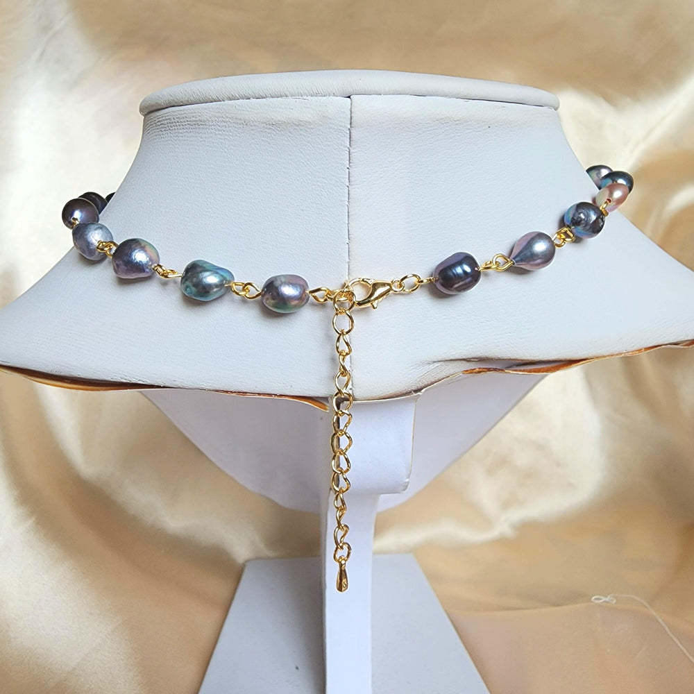 
                  
                    This elegant choker is crafted with gold-plated brass, stainless steel findings, and tarnish-resistant copper wire, featuring a romantic design of flower-shaped black freshwater pearls alongside iridescent black seed bead details.
                  
                