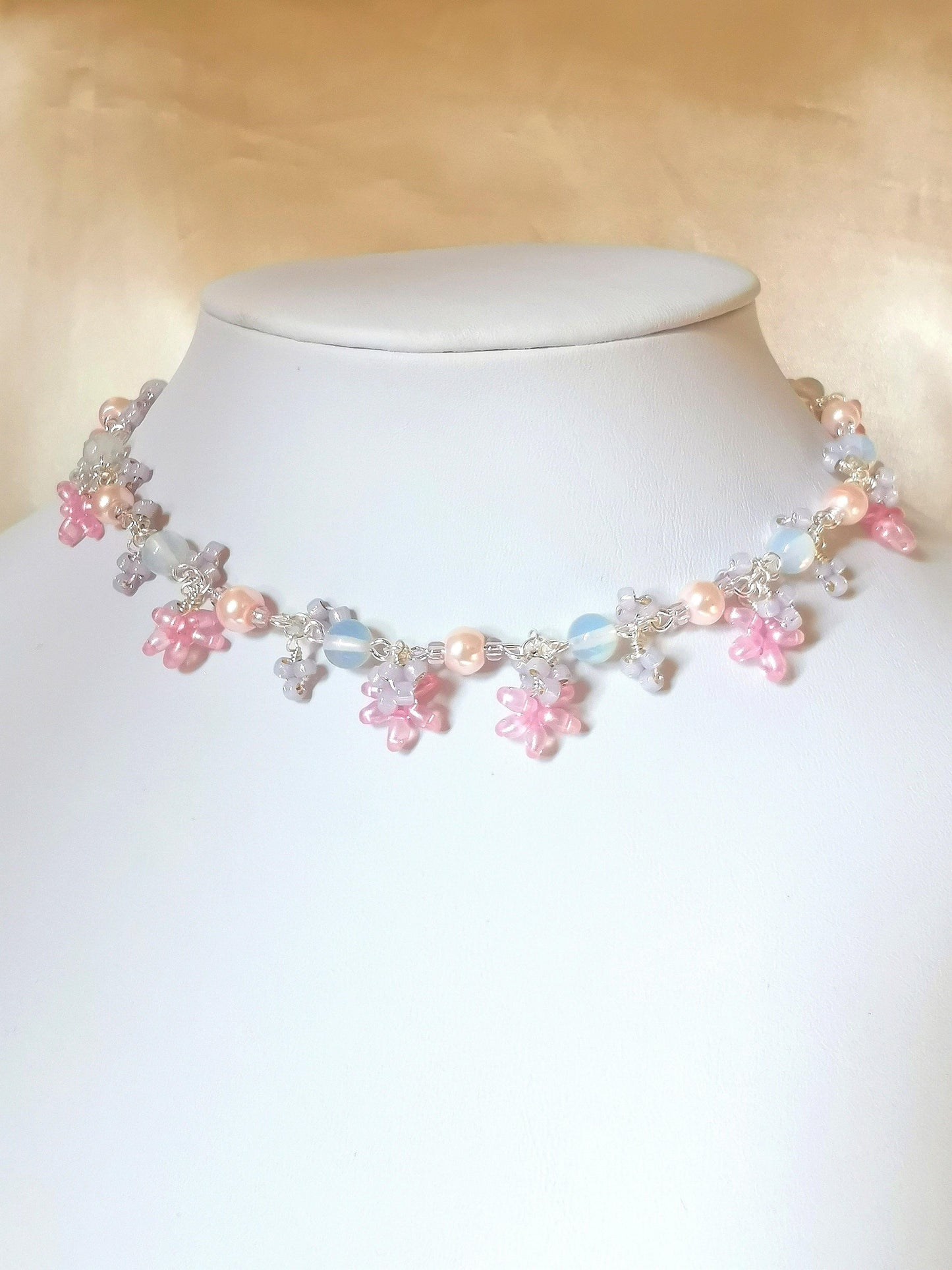 This is a sweet handmade silver choker with beautiful opalescence from the opalite beads and cute pastel flower-like details in pink and silvery purple.  This choker-necklace is handcrafted with glass pearls, opalite beads, silvery purple glass seed beads, glass twin beads, in silver-plated findings and tarnish resistant copper wire.