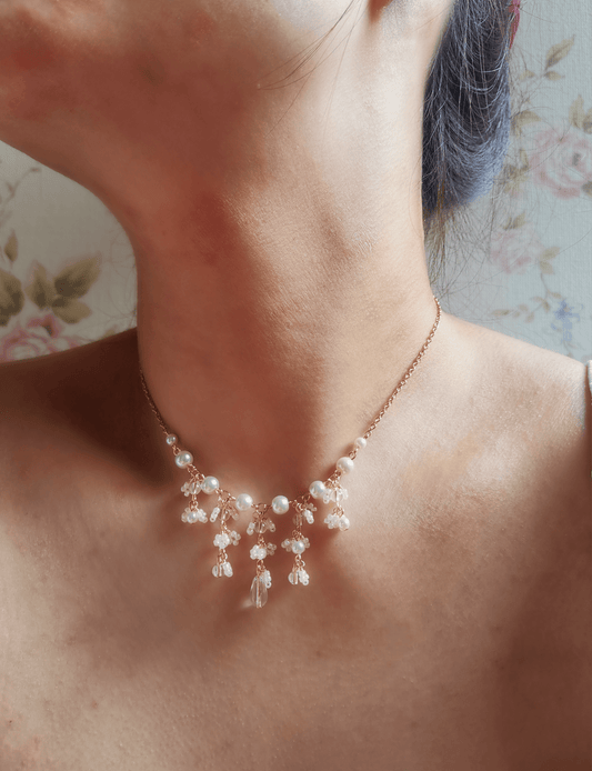 This dainty made-on-order Daphne necklace features a cascade of pearls and quartz crystal beads, accompanied by flower like details made of seed beads. A fanciful but understated elegant piece.