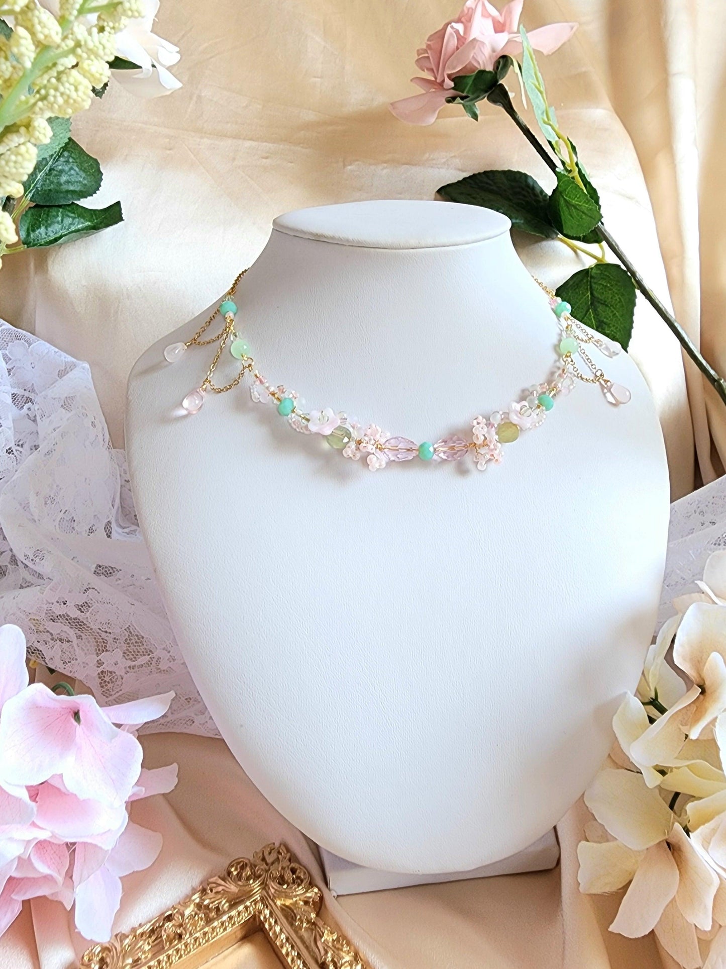 Roses are a perennial beauty surrounding the Magic Pond, captivating viewers with its emerald waters reflecting under the light of dreams. This necklace features glass beads, prehnite, Czech glass beads, brass artistic wire and gold-plated findings.