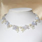 This is an elegant silvery necklace handcrafted with blue lace agate chip beads, ivory glass pearls, framed by translucent purple seed beads and translucent yellow 'flowers' made of glass beads.